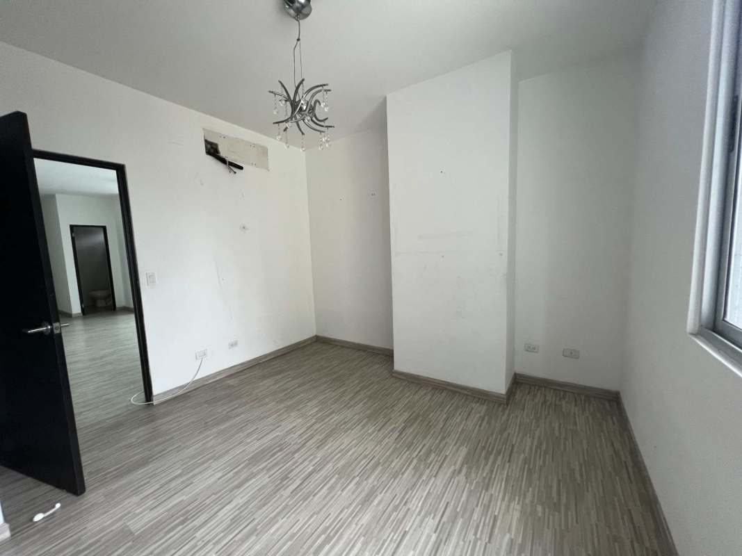 Modern empty bedroom with tile floor large window en suite bath PH Galeria Uno Panama