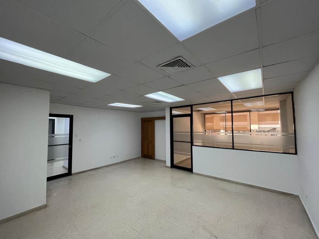 Empty commercial office with tiled floors, white walls, drop ceiling lights in Marbella Panama