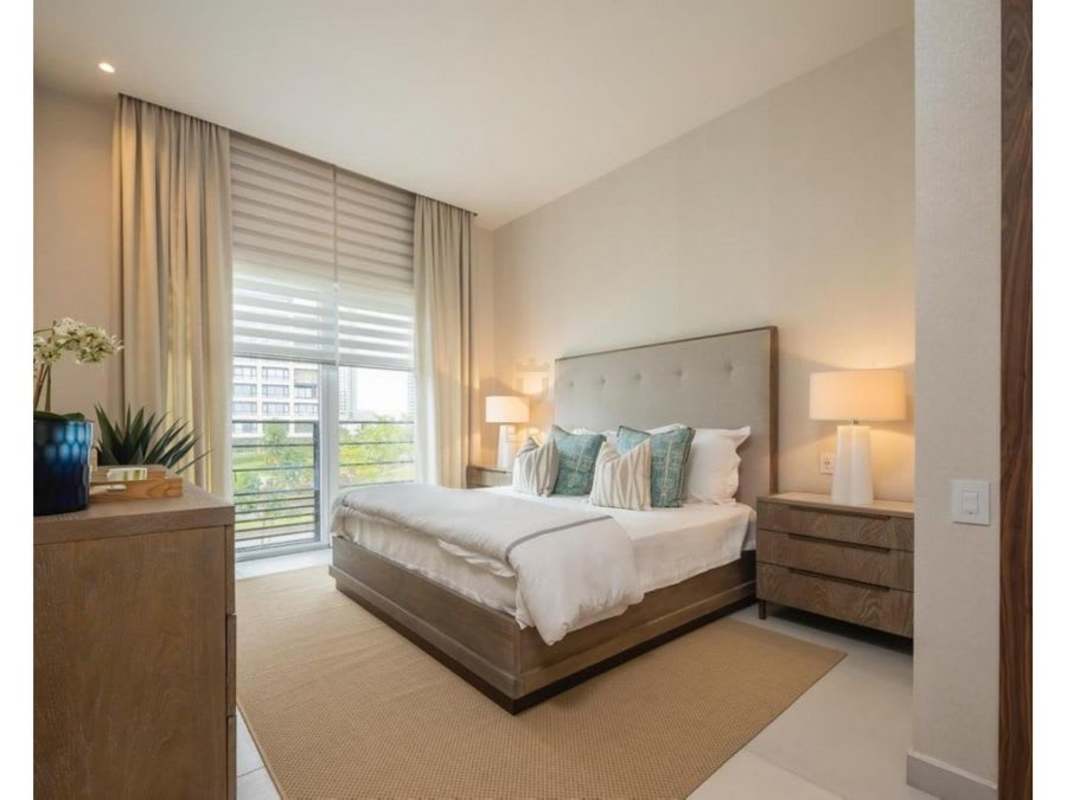 Elegant dining room with wooden table, gold chandelier, and art at The Woods Santa María