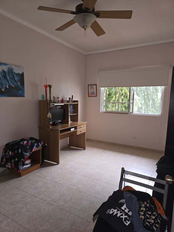 Large traditional bedroom with tile floors, closets, ceiling fan, arched window in luxury house Costa del Este, Panama