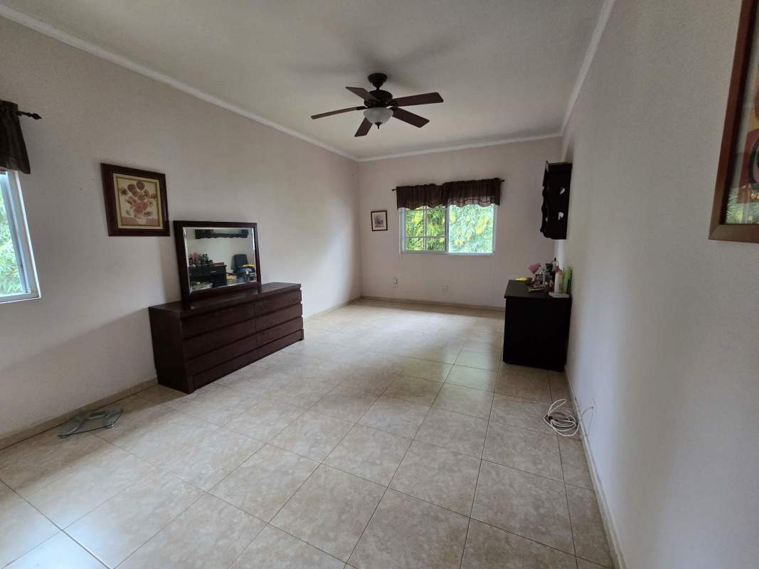 Bright dining area with ceramic tile floor, wooden dining set, contemporary lighting in Costa del Este house Panama