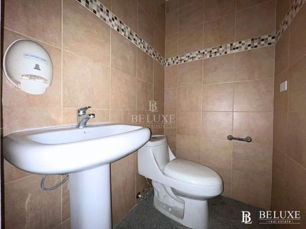 Accessible commercial bathroom with pedestal sink grab bar toilet tiles SFC Tower Panama