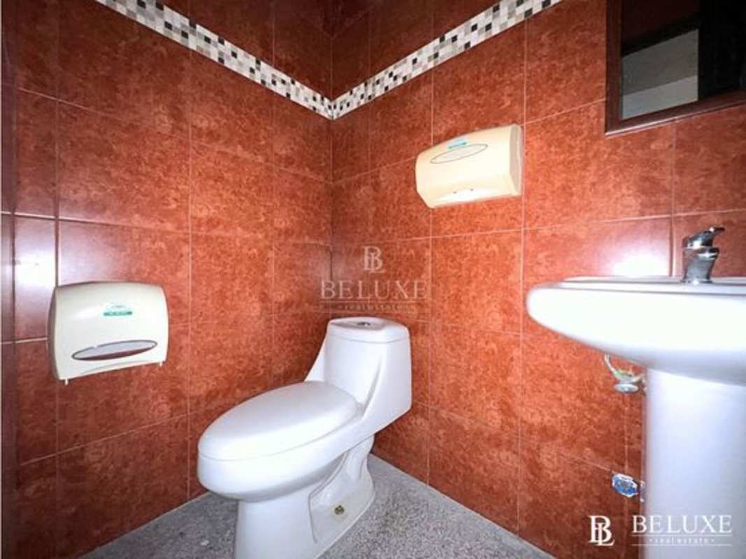 Commercial restroom with pedestal sink toilet and tiles in SFC Tower Obarrio