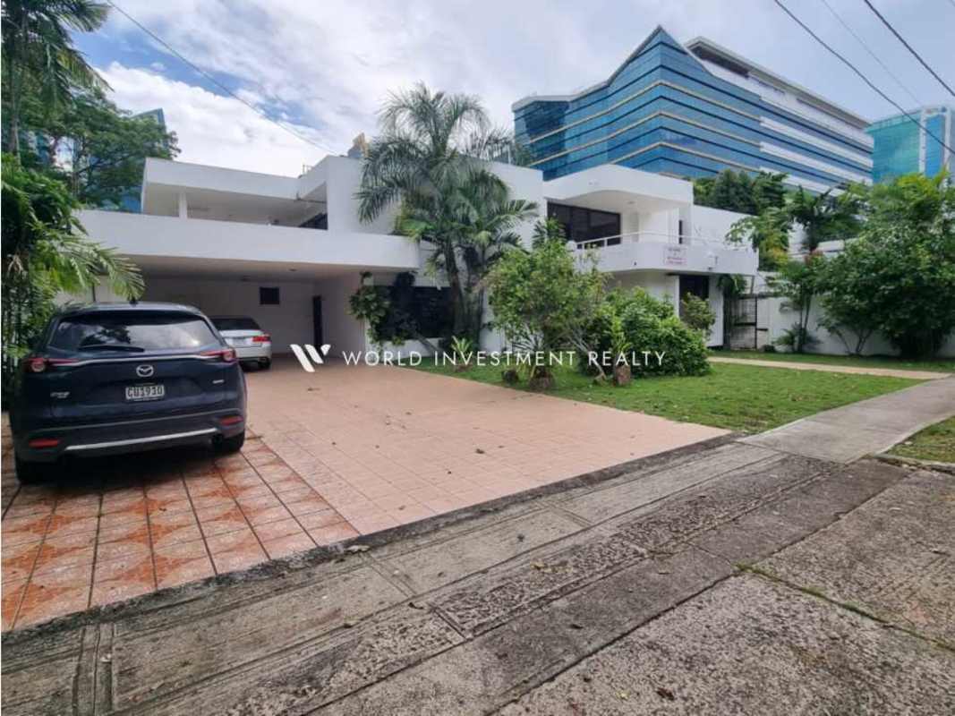 Wide hallway with marble floor leading to sun-lit living room with orange sofas Panama City
