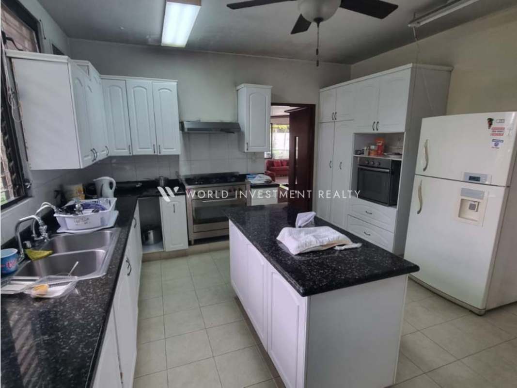 Open living and dining area with wooden ceiling, marble steps and large windows in Bella Vista property