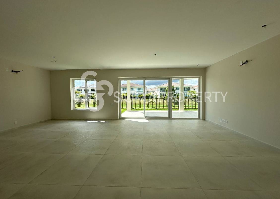 Large living room with windows and sliding doors overlooking garden in Santa María Golf Villa Panama