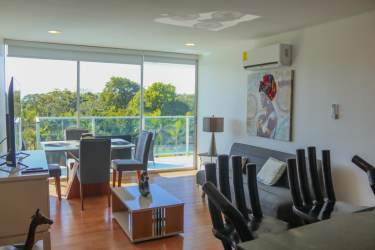 Modern living dining room with floor-to-ceiling windows and balcony access at Bala Beach Caribbean
