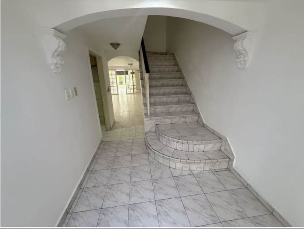 Marble staircase with arch and bright hallway in Betania house interior Panama