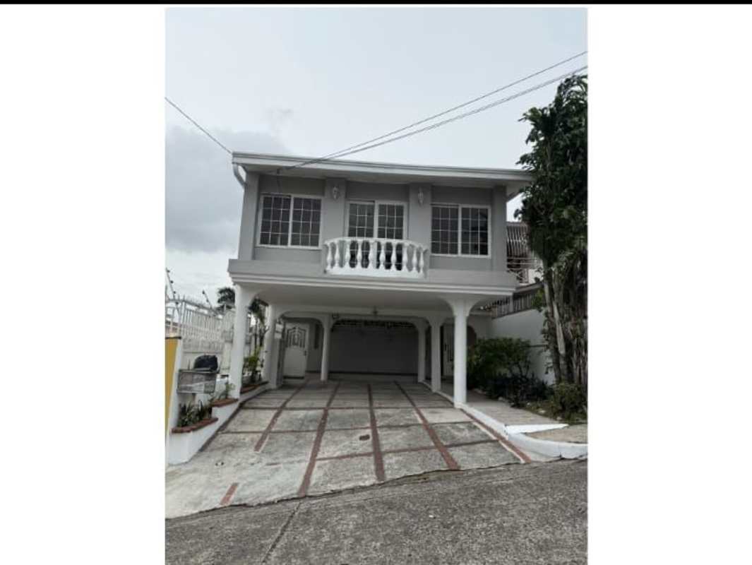 Large entry foyer with ornate staircase and tiled floor in Betania house Panama