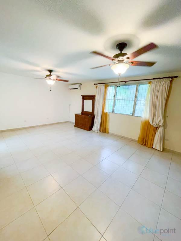 Spacious backyard with perimeter wall, garden space and paved walkways in rental home Panama