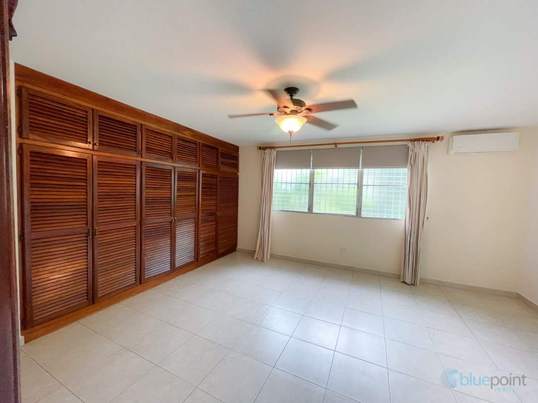 Large covered terrace with tile floors and view of fenced garden space in rental home Las Cumbres