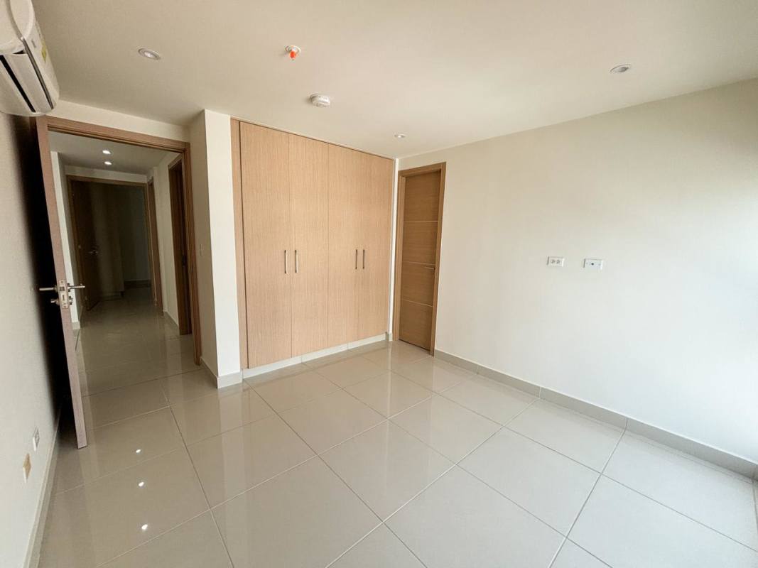 Spacious bedroom with AC unit, closet, light tile floors in PH Torres del Parque Panama rental