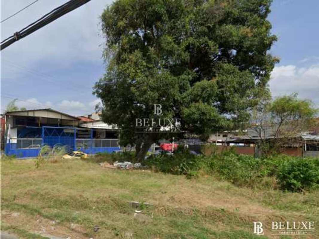 Empty urban lot with open grass and surrounding commercial buildings in Panama City Rio Abajo