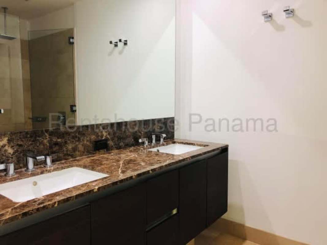 Modern bathroom with marble double sinks and glass shower in PH The Ocean Club Punta Pacifica Panama