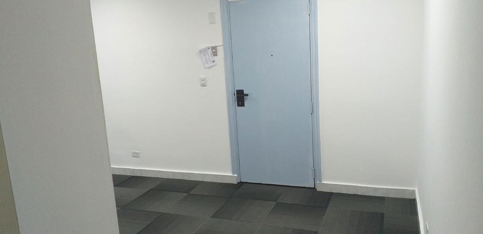 Clean minimalist office hallway with light blue door ceramic tile floor in Marbella Tower