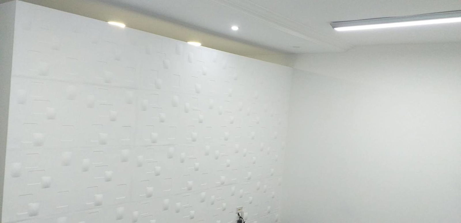 Spacious office with creative 3D textured accent wall recessed lighting white minimalist design