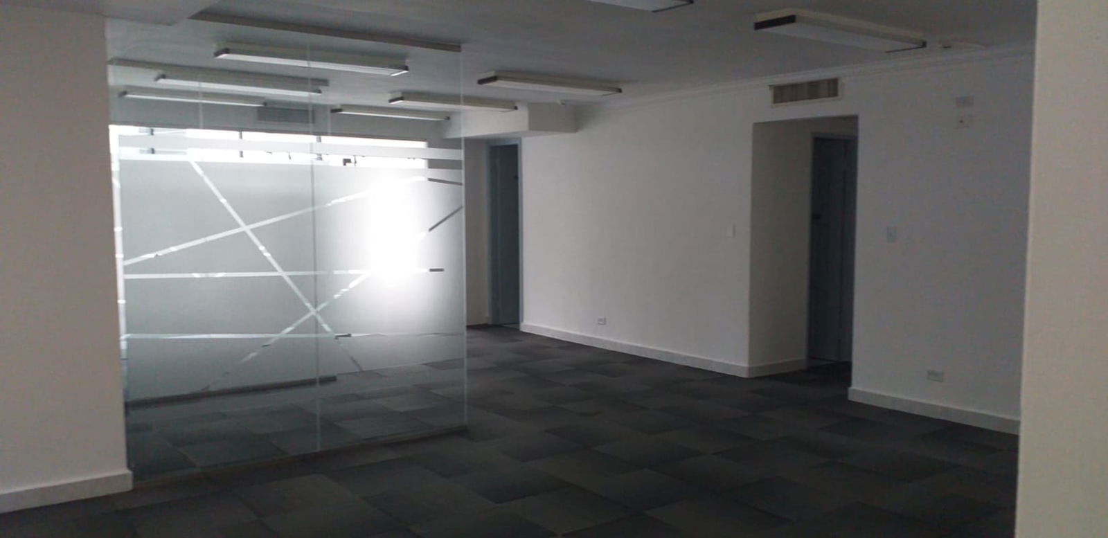 Modern office interior with glass dividing walls tile floors and recessed lights Panama City