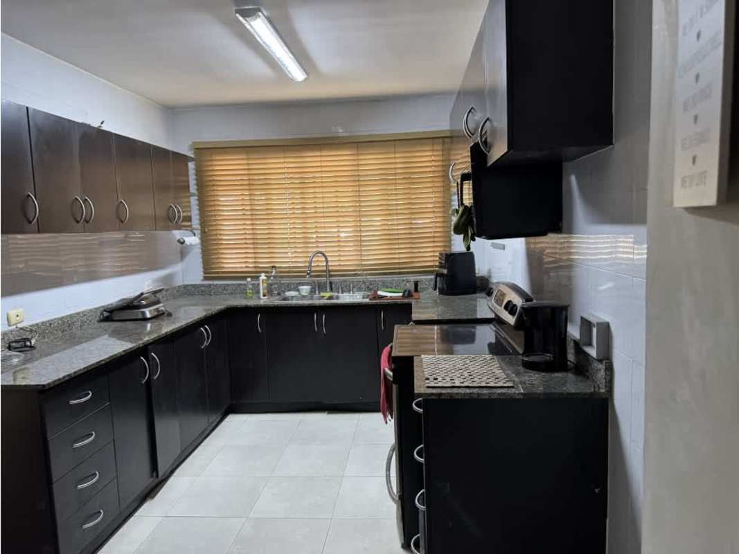 Black and granite finished kitchen with cabinets and microwave in Villa Tivoli Brisas del Golf