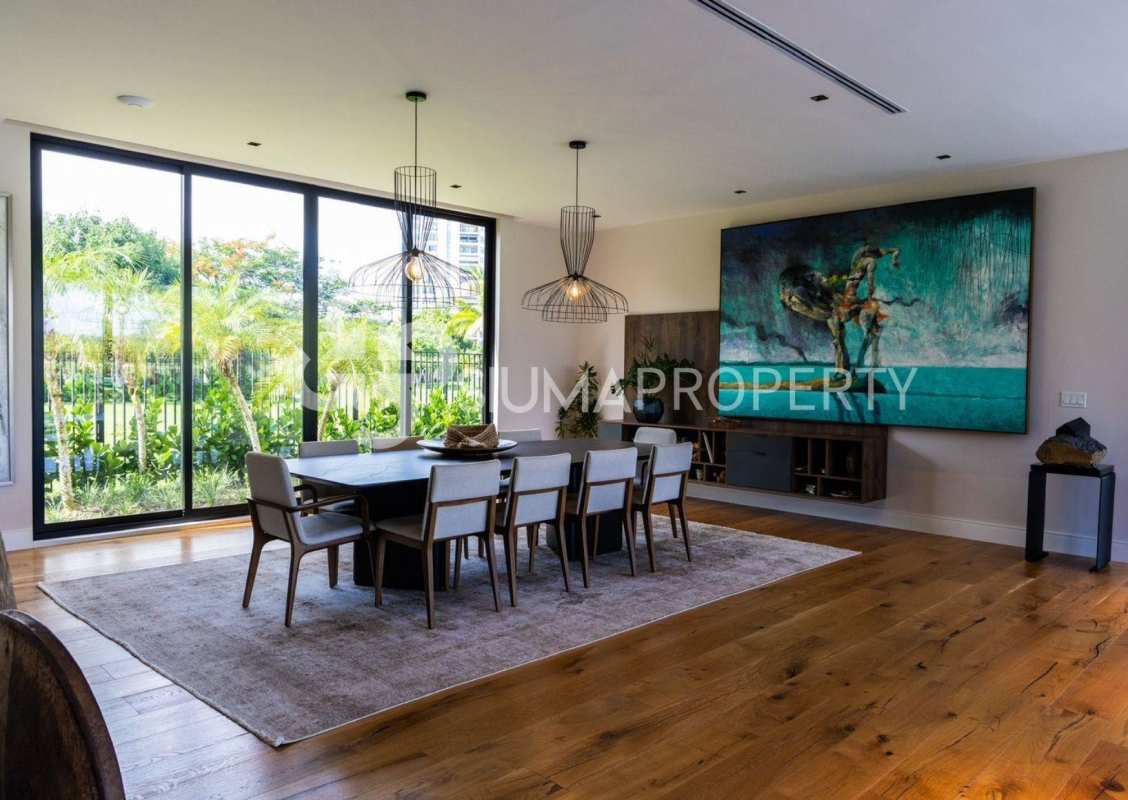 Family room with sectional sofa and wood staircase overlooking garden in luxury home Santa Maria Panama
