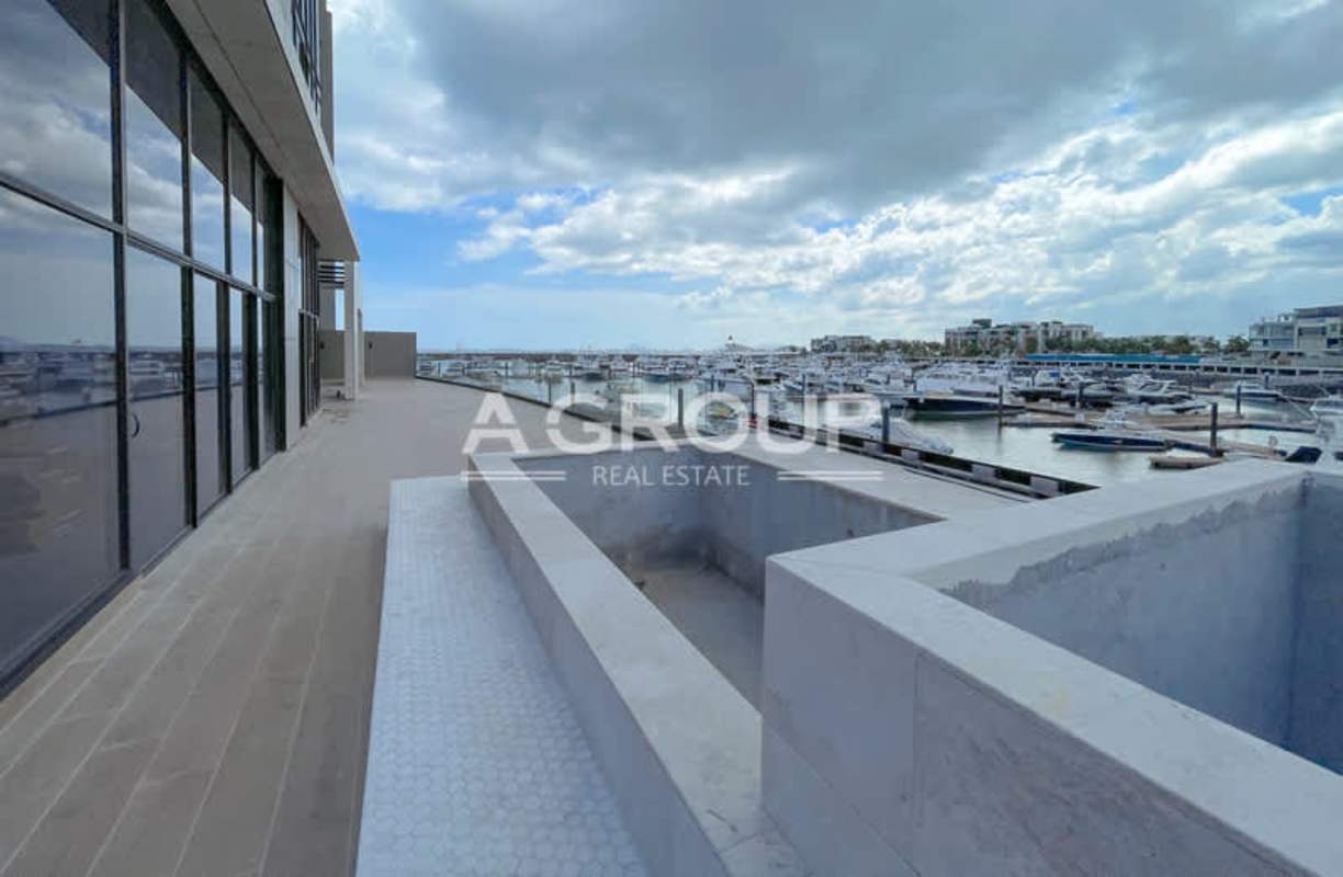 Spacious waterfront terrace with glass railing overlooking marina and ocean on Ocean Reef Islands