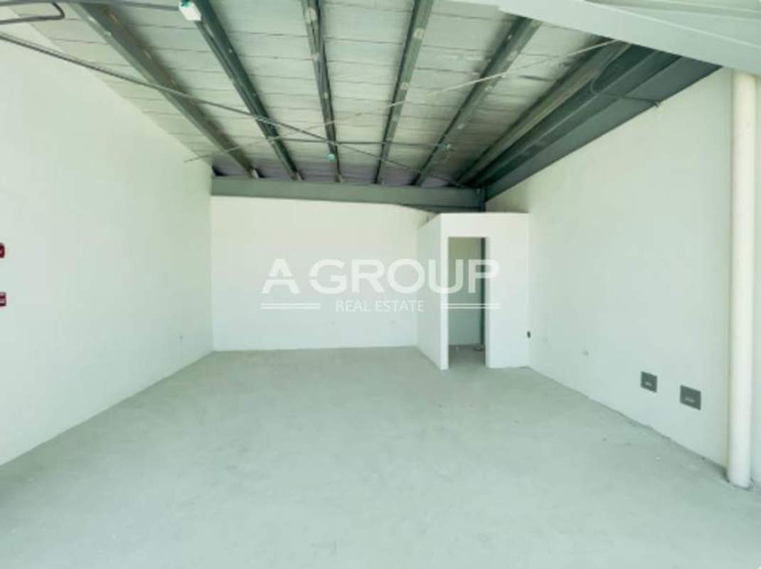Empty industrial warehouse space with enclosed storage area exposed metallic ceiling Panama Viejo