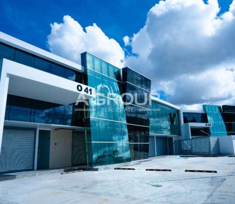 Modern commercial center facade with reflective windows, numbered units, and ample parking in Panama City