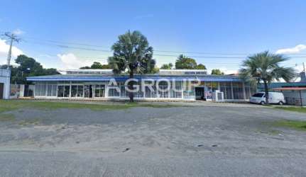 Facade of modern commercial center with glass windows and parking facing Panamericana in Nueva Gorgona Panama