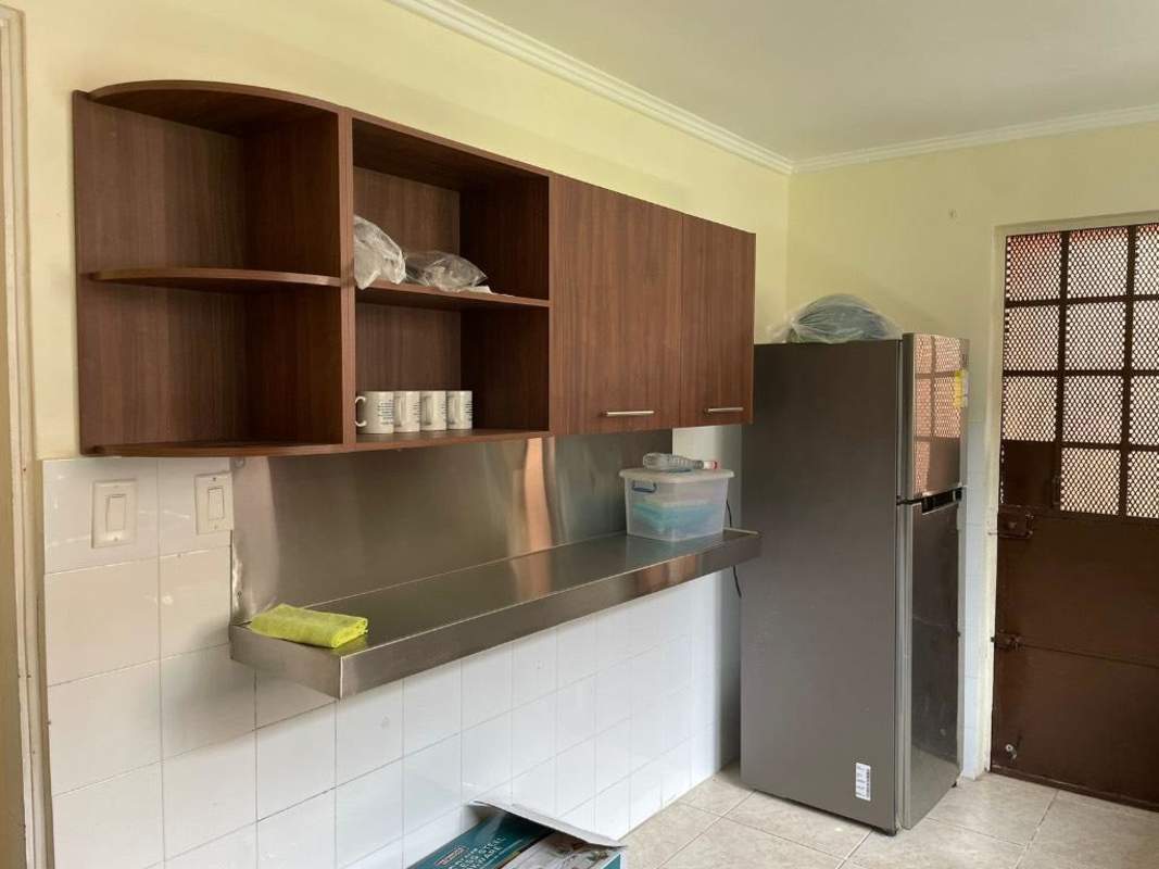 Kitchen interior with stainless countertops, tiled floors, wooden cabinets Brisas del Golf Panama