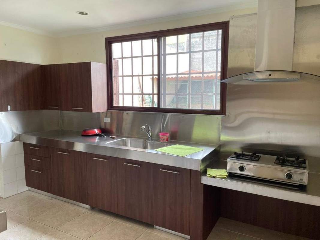 Kitchen area with window, stainless counters and backsplash, wooden cabinetry Brisas del Golf Panama