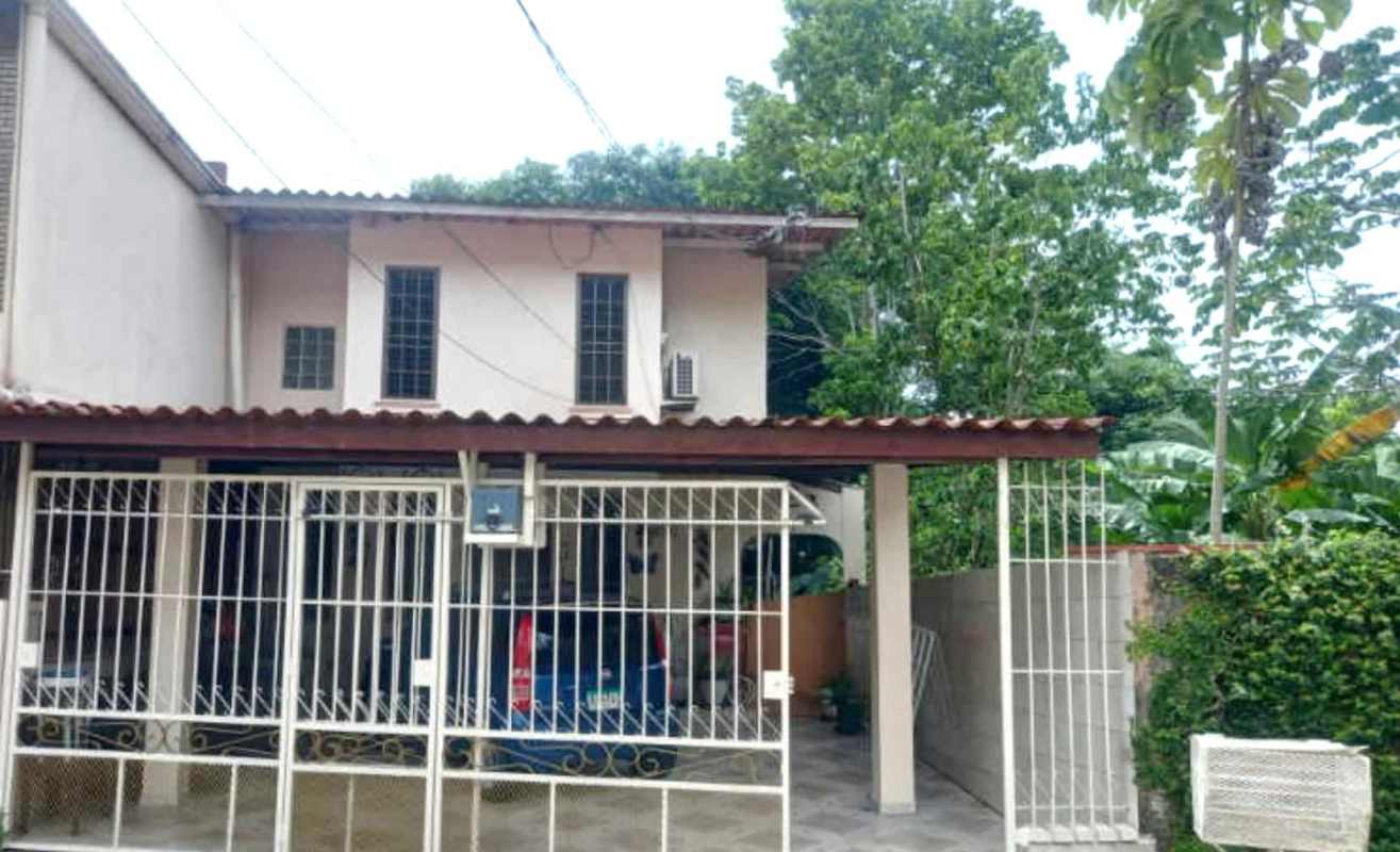 Exterior of two-story beige house with metal gate, carport PH Torres de Toscana Panama City