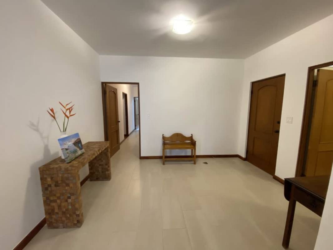 Hallway in restored Casco Viejo apartment with tile floors, white walls, colonial charm