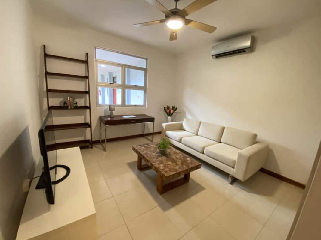Living room Casco Viejo with French doors, ceiling fan, white sofa, wooden furniture