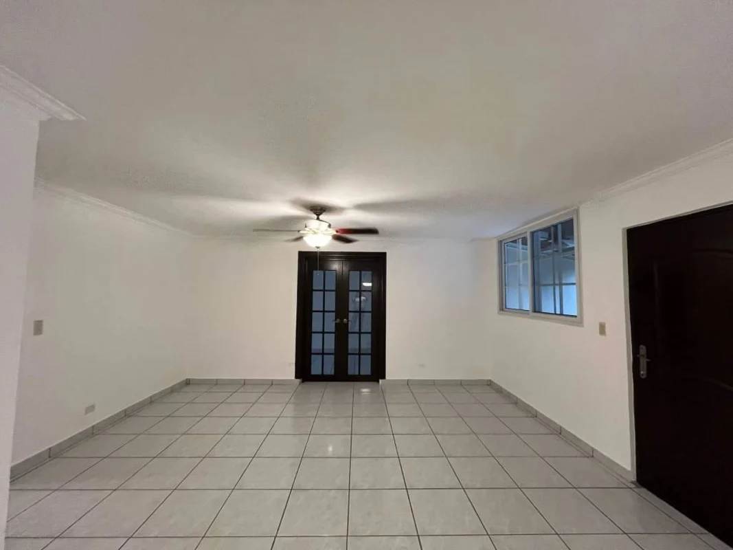 Open living room with ceiling fan, white tiles, large windows and French doors leading to patio at Torres de Toscana Altos de Panama