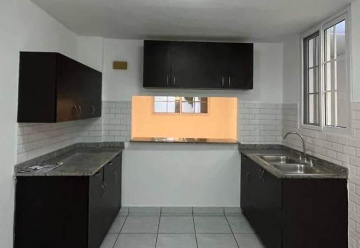 Spacious modern granite countertop kitchen with double sink, black cabinetry, subway tile backsplash in Torres de Toscana Condado del Rey