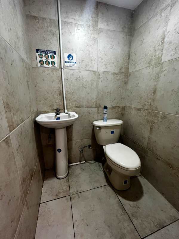 Simple tiled bathroom with pedestal sink and toilet PH Jardines Hotel Panama Obarrio