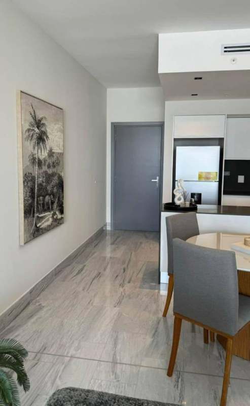 Modern dining space and open kitchen at Nuovo by Armani Casa with marble floors and stylish furnishings Panama City