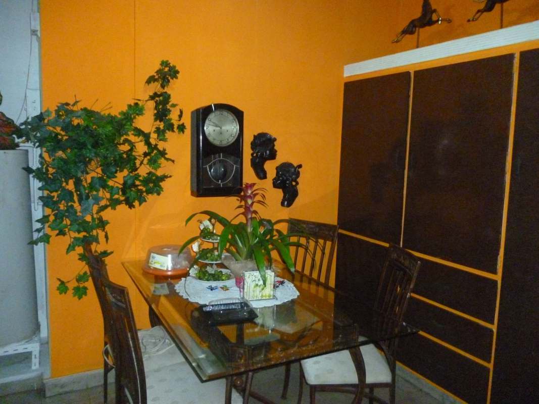 Living room with decorative wall art, indoor plants, armchairs, and natural light in Altos del Golf house for sale