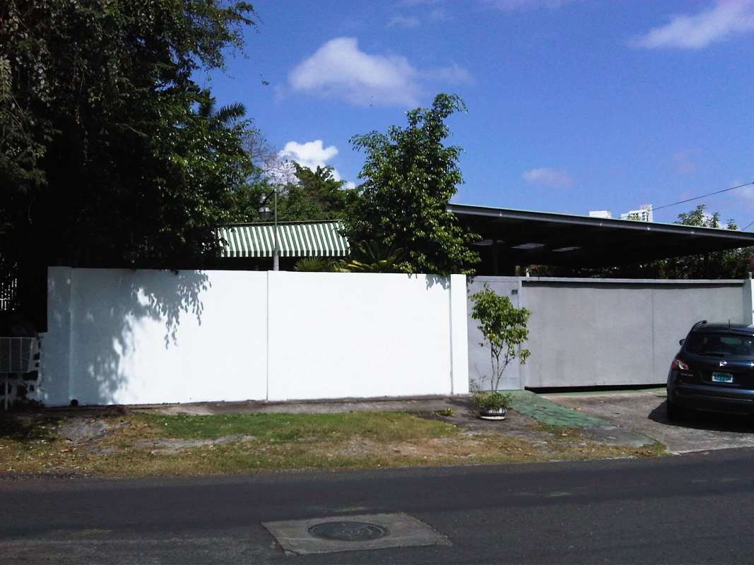 Dining room featuring orange walls, glass table, built-in cabinets and natural lighting in Panama house