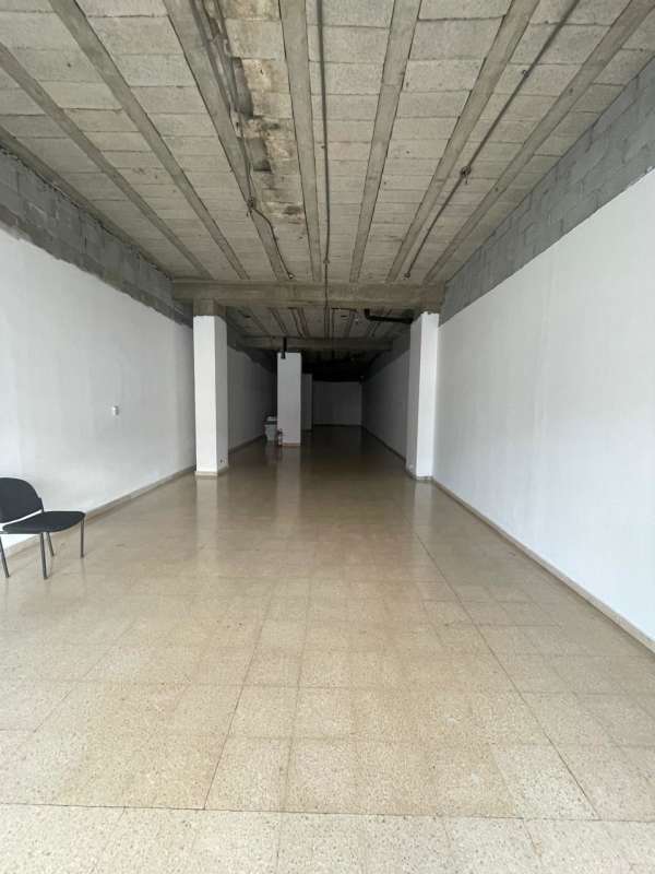 Large open commercial space with tiled flooring, exposed ceiling and columns, located in busy Transístmica area Panama City