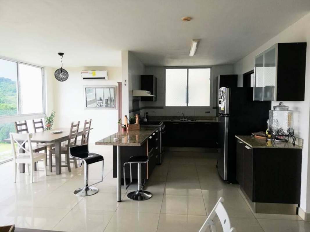 Dining room with windows showing pool area, porcelain tiles in PH Pine Hills Albrook Panama apartment