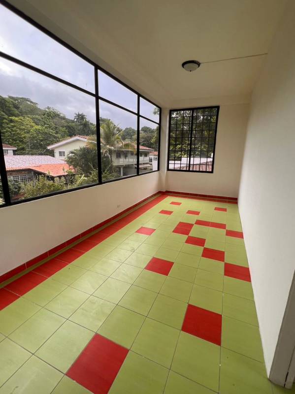 Unfurnished living room with tiled floors, large windows with iron grilles at Panama City house