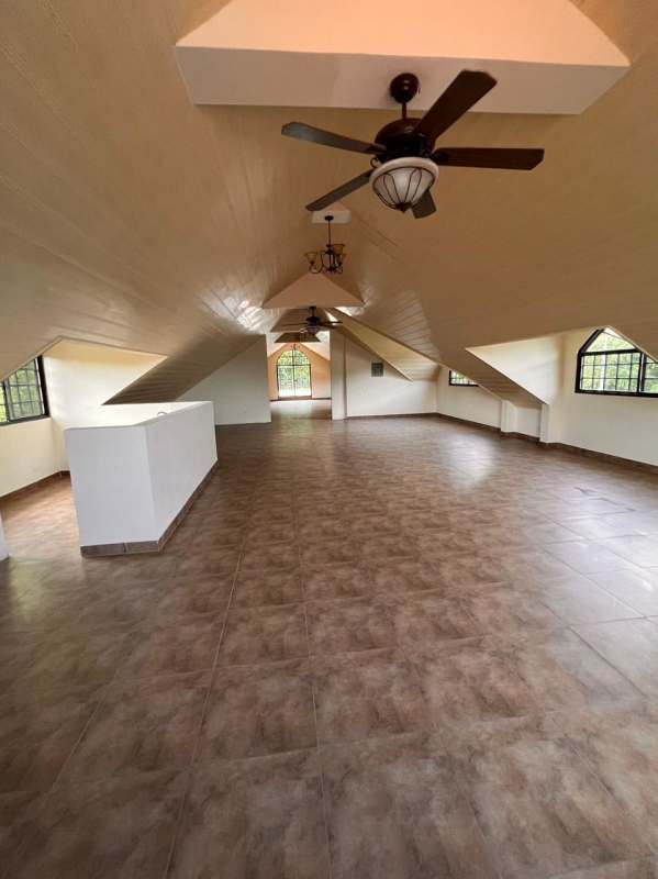 Multi-story Mediterranean house with stone accents, arched windows, tiled roof, landscaped yard, Panama City