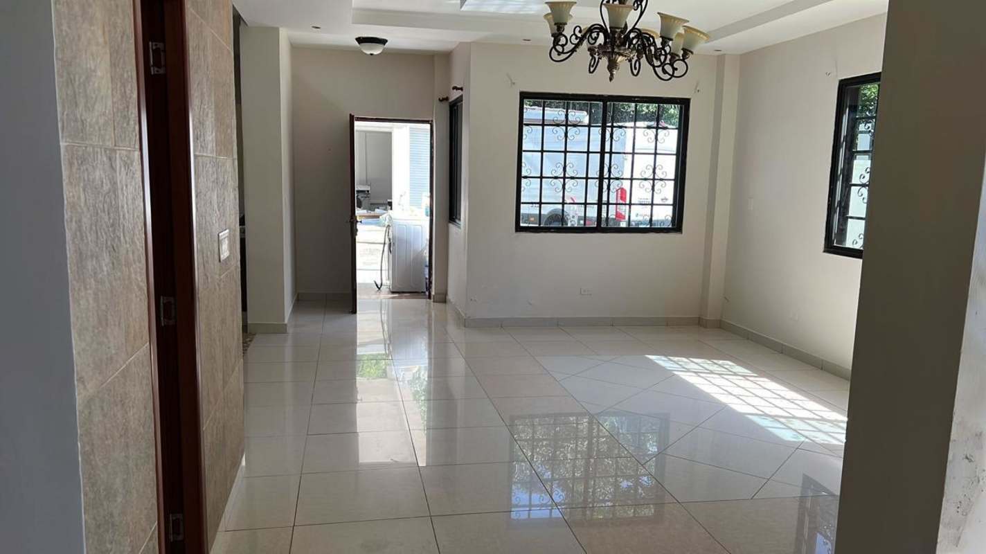 Large traditional living and dining room with chandeliers, tile floors, iron stair rail, Llanos de Curundu house