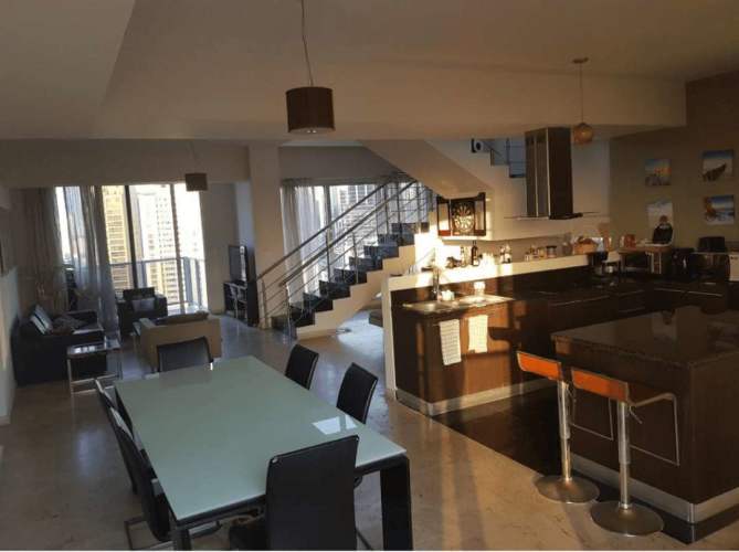 Spacious bedroom with padded headboard, balcony with glass railing and city ocean view at Sol Marina Tower