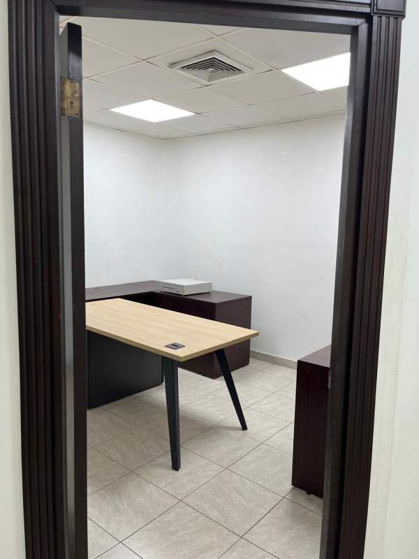 Minimalist office room with window blinds, wooden desks, tiled floors in PH Office Plaza San Francisco