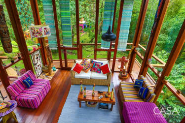 Eclectic living room with colorful decor large windows and forest views in mountain estate Altos del María