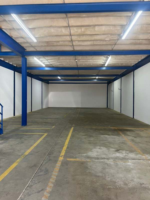 Warehouse interior spacious industrial look with concrete floors, blue beams Los Pueblos Juan Díaz Panama