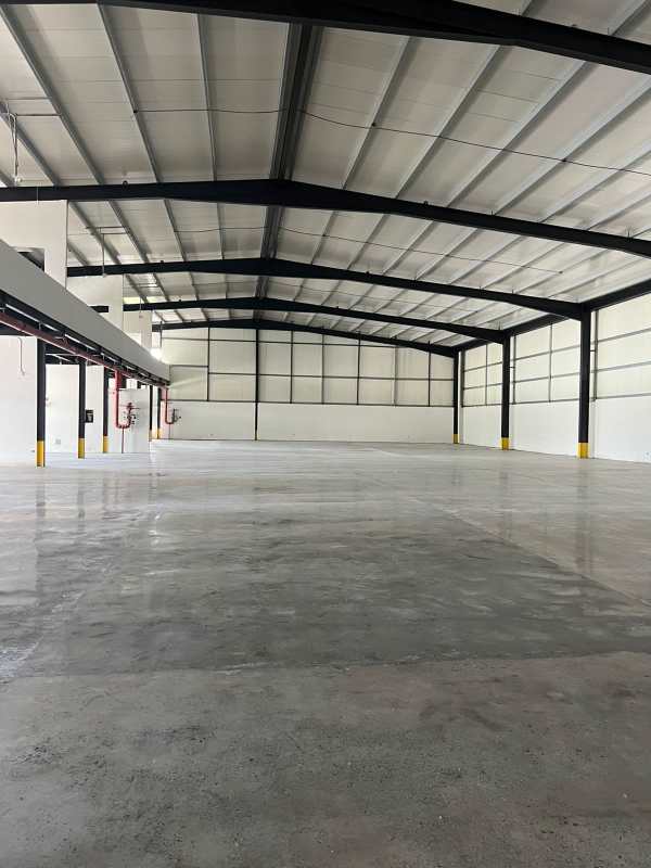 Large warehouse industrial space with polished floors and exposed steel beams