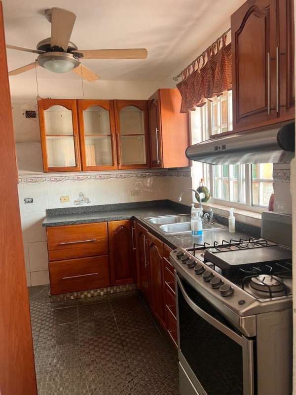 Wood cabinets kitchen with granite countertop and gas stove in Residencial Bariloche Panama for sale