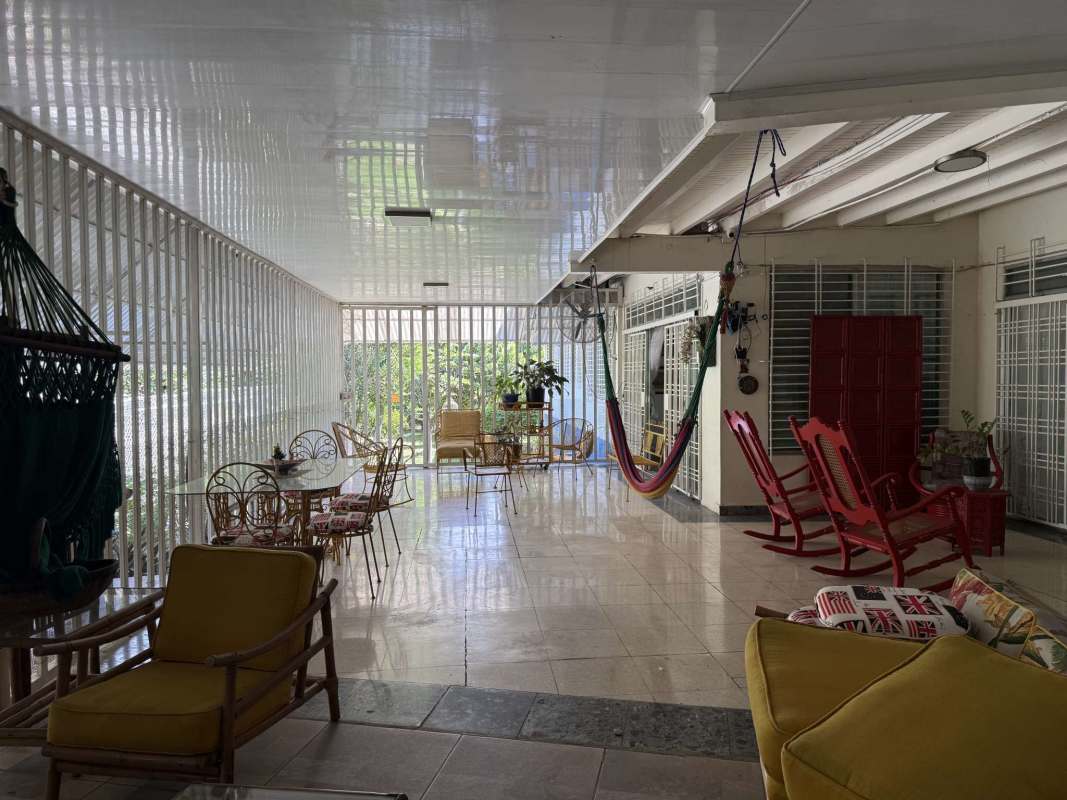 Colorful enclosed patio wicker furniture hammocks tropical garden view luxury Panama home